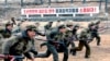 북한 조선중앙통신이 지난 13일 공개한 노동적위대원들의 군사훈련 장면. 미국에 대한 적대 구호가 세겨져 있다.