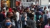 Grupos de personas, la mayoría protegidos con máscaras, llenan una popular calle de tiendas en Sao Paulo, Brasil, el 15 de julio de 2020.