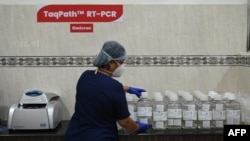Una técnica de laboratorio trabaja en un laboratorio equipado para examinar a los pacientes de COVID-19. [Archivo]