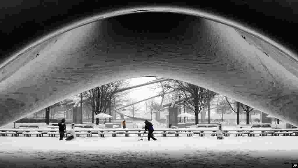 A equipa de limpeza do Millennium Park retira a neve à volta da Cloud Gate, do escultor Anish Kapoor, Chicago, Jan. 2, 2014.
